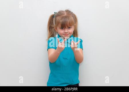 Una ragazza di 4 anni cheey che si attacca 2 dita in su. Foto Stock