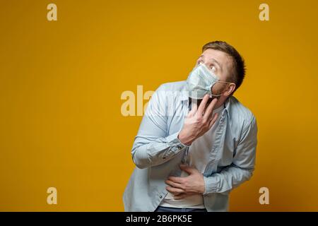 L'uomo in una maschera protettiva e medica è molto spaventato, ha paura di contrarre un virus pericoloso. Spazio di copia. Foto Stock