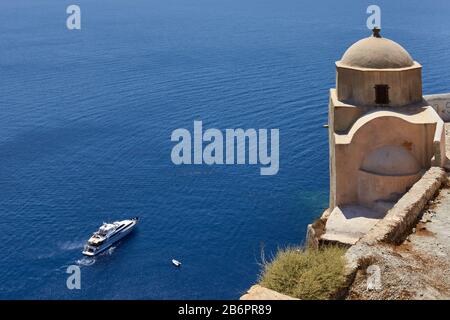 Oia, Santorini, Grecia, 21 agosto 2013: Vista di una piccola chiesa e di uno yacht di lusso che naviga nel mare blu Foto Stock