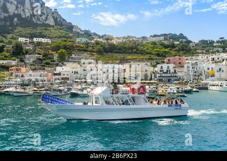 Isola DI CAPRI, ITALIA - AGOSTO 2019: Gruppo di persone a bordo di una barca a motore in un'escursione turistica alla Grotta Azzurra sull'Isola di Capri. Foto Stock