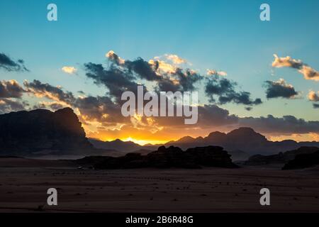 Regno di Giordania, deserto di Wadi Rum, cielo di tramonto impressionante e luce sul deserto nelle tenebre e nelle ombre. Bella fotografia di viaggio. Un bellissimo deserto potrebbe essere esplorato durante il safari. Immagine colorata Foto Stock