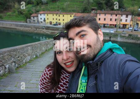 Il suggestivo e famoso Ponte della Maddalena di Lucca costruito in mattoni su un fiume in un antico borgo medievale di Borgo a Mozzano Foto Stock