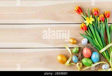 Felice concetto di Pasqua. Background pasquale di congratulazioni. Uova di Pasqua e fiori. Foto Stock