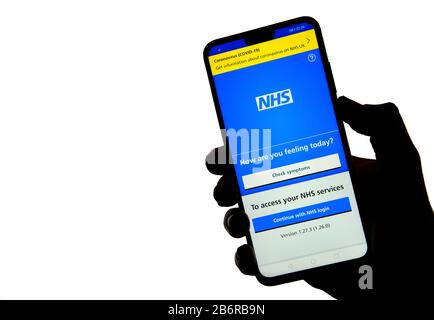 Stone / Regno Unito - 11 marzo 2020: App NHS sulla silhouette di uno smartphone tenere a portata di mano. Foto Stock