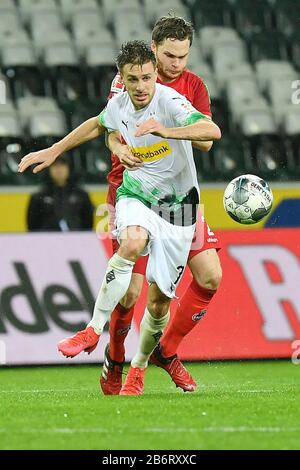 Monchengladbach, Germania. 11th Mar, 2020. Patrick Herrmann (fronte) di Monchengladbach vies con Benno Schmitz di Colonia durante una partita tedesca della Bundesliga tra la Borussia Monchengladbach e il FC Cologne a Monchengladbach, Germania, 11 marzo 2020. A causa dello scoppio del COVID-19, la partita è stata tenuta a porte chiuse per la prima volta nella storia della Bundesliga, accordandosi ai media tedeschi. Credit: Ulrich Hufnagel/Xinhua/Alamy Live News Foto Stock