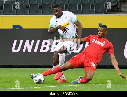 Monchengladbach, Germania. 11th Mar, 2020. Marcus Thuram (L) di Monchengladbach vies con Kingsley Ehizibue di Colonia durante una partita tedesca della Bundesliga tra la Borussia Monchengladbach e il FC Cologne a Monchengladbach, Germania, 11 marzo 2020. A causa dello scoppio del COVID-19, la partita è stata tenuta a porte chiuse per la prima volta nella storia della Bundesliga, accordandosi ai media tedeschi. Credit: Ulrich Hufnagel/Xinhua/Alamy Live News Foto Stock