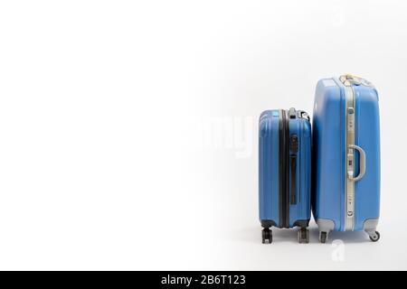 Due valigie blu isolate su sfondo bianco. Valigia blu. Foto Stock