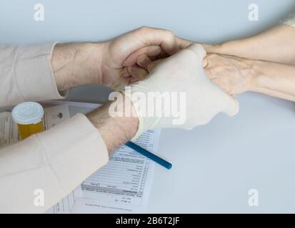 Le mani del medico davanti alle mani del paziente. Tiene le mani del suo paziente. Foto Stock