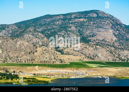 Vista sulla valle di Okanagan con area residenziale e campi di coltivazione di frutteti Foto Stock