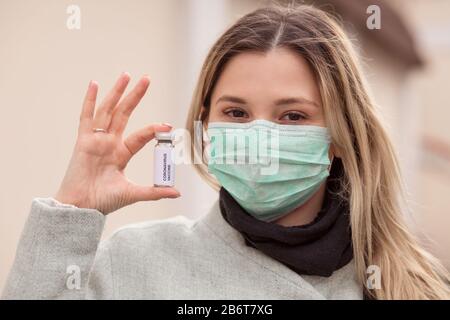 Donna che contiene un flaconcino con Vaccino Coronavirus. Esso viene utilizzato per la prevenzione, l'immunizzazione e il trattamento da virus corona infezione malattia 2019, COVID-19, NCO Foto Stock