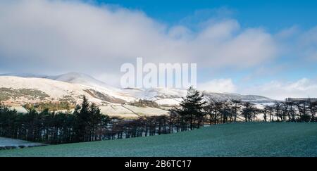 Fattoria scozzese e terra lungo la valle tweed nella neve d'inverno. Vicino Drumelzier, Tweed Valley, Scottish Borders, Scozia Foto Stock