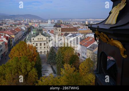 Vista dall'alto di Kosice (Slovacchia) dalla torre della Cattedrale di Santa Elisabetta. Quadrato con alberi gialli in primo piano. Teatro cittadino nel mezzo della composizione. Foto Stock
