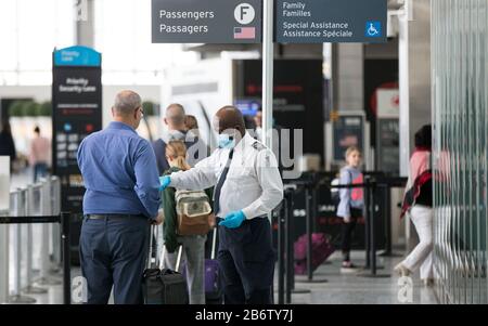 Toronto, Canada. 11th Mar, 2020. Un membro del personale (C) dell'autorità canadese per la sicurezza dei trasporti aerei (CATSA) in servizio con maschera facciale e guanti è visibile al Terminal 1 dell'aeroporto internazionale Pearson di Toronto, Canada, 11 marzo 2020. Finora in Canada sono stati segnalati almeno 93 casi confermati di COVID-19 e un decesso. Credit: Zou Zheng/Xinhua/Alamy Live News Foto Stock