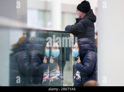 Toronto, Canada. 11th Mar, 2020. Una donna che indossa una maschera facciale appare dritta mentre si trova nell'area di prelievo passeggeri al Terminal 1 dell'Aeroporto Internazionale Pearson di Toronto, Canada, 11 marzo 2020. Finora in Canada sono stati segnalati almeno 93 casi confermati di COVID-19 e un decesso. Credit: Zou Zheng/Xinhua/Alamy Live News Foto Stock