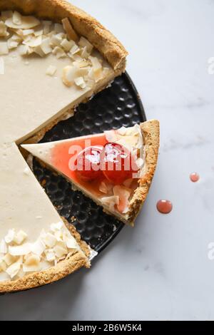 Torta di crema di cocco con confettura di fragole su sfondo di marmo Foto Stock