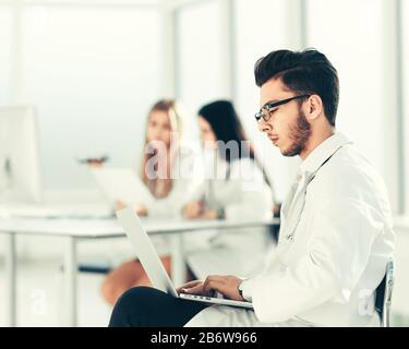 Medico funziona su un computer portatile nella stanza di ospedale Foto Stock