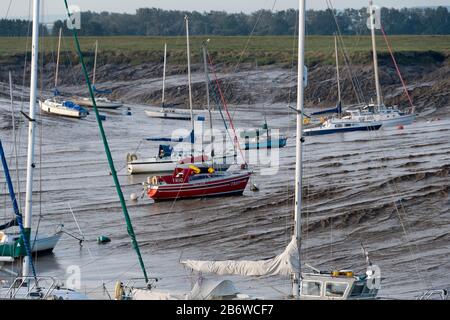 Gli yacht si aggirano alle ormeggi sul letto del fiume di marea, fiume Parrett, Burnham-on-Sea, Somerset, Inghilterra Foto Stock