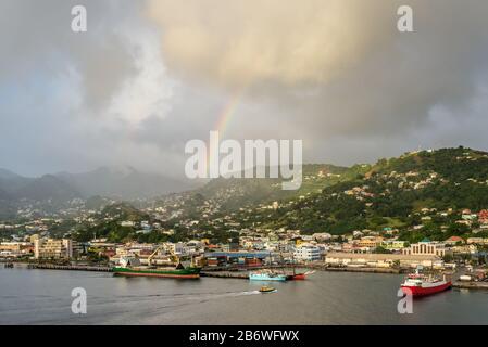 Kingstown, Saint Vincent e Grenadine - 19 dicembre 2018: Arcobaleno colorato nel cielo sopra la città di Kingstown con cielo drammatico, dopo le las Foto Stock