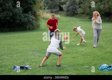 Un colpo di una famiglia che gioca a calcio insieme su un campo. Foto Stock