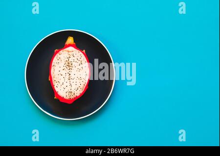 Pitaya. Il primo piano di frutti di drago maturi su piastra su sfondo giallo. Foto Stock