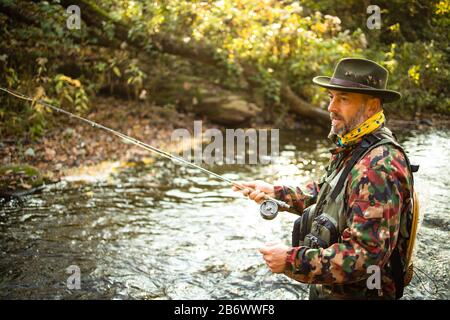 Pescatore a mosca la pesca con la mosca su di uno splendido fiume di montagna Foto Stock