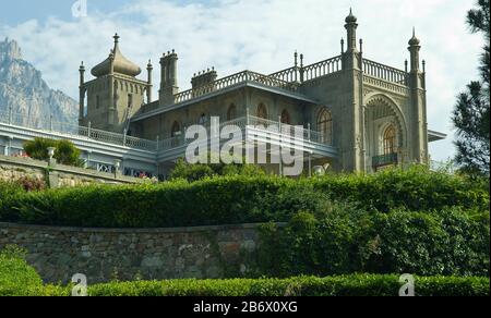 Il Palazzo Vorontsov o il Palazzo Alupka è un palazzo storico situato ai piedi delle montagne della Crimea vicino alla città di Alupka in Crimea. Verde Foto Stock