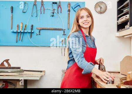 Donna come apprendista lavora in un laboratorio di falegname Foto Stock