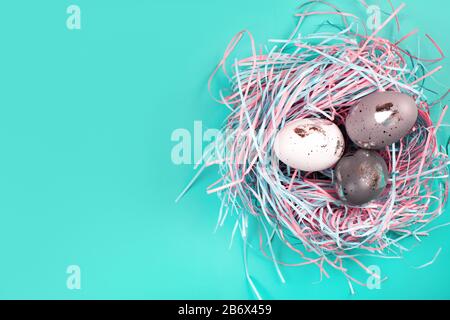 Nido ornitologico decorativo con creative uova d'argento dipinte a mano su sfondo pastello blu. Concetto di Pasqua. Inserire il testo. Foto Stock
