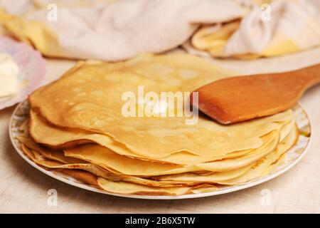 Pancake sul piatto. Molti pancake sono accatastati. Pancake sottili con crosta croccante. Maslenitsa. Frittelle per colazione e carnevale. Foto Stock