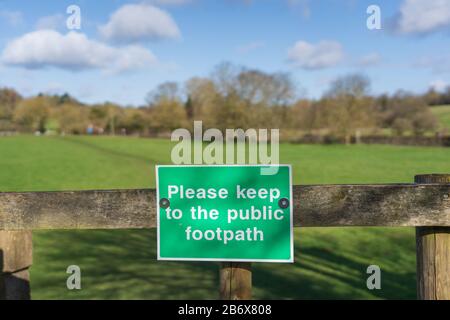 Cartello di campagna sul cancello che istruisce la gente a mantenere al sentiero pubblico. Molto Hadham, Hertfordshire. REGNO UNITO. Foto Stock