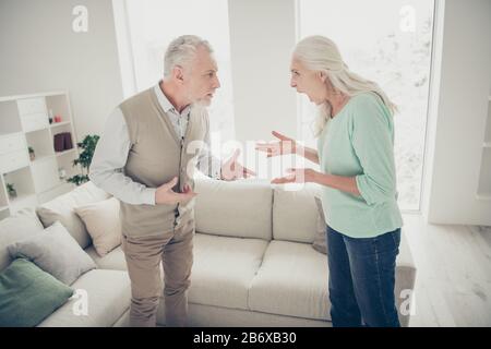 Foto del profilo laterale di nervoso negativo in cattivo umore donna che urla su scioccato annoiato uomo Foto Stock