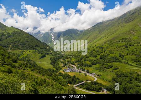 Villaggio Di Le Plan, Alta Garonna, Occitanie, Francia. La D118 conduce attraverso il villaggio e al Parco Nazionale dei Pirenei montagnosi oltre. Foto Stock