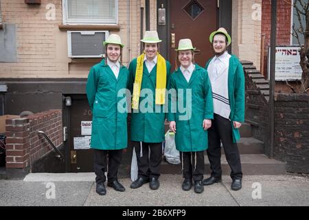 4 adolescenti ebrei Satmar nei loro costumi Purim raccogliere la carità per la loro scuola. A Williamsburg, Brooklyn, New York City. Foto Stock