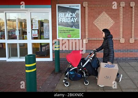 29/11/2019. Solihull, Regno Unito. Un acquirente con una sedia di spinta e una casella sul Venerdì nero a retail park a Solihull. Foto Stock