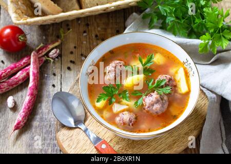 Il concetto di cibo sano e dietetico, piatto vegetariano. Deliziosa zuppa di verdure con palle di fagioli su un tavolo rustico. Foto Stock