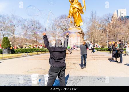 Central Park, New York - 8 marzo 2020: I giganti Bubble Makers si esibiscono per i turisti entusiasti di Central Park. Foto Stock