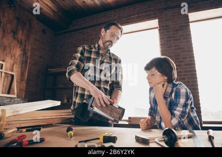 Basso angolo di vista di due bella intelligente persona creativa messa a fuoco master dad insegnamento figlio di vecchia moda interessante professione costruzione Foto Stock