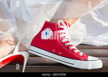 Bordeaux , Aquitaine / Francia - 11 07 2019 : Bride piedi Wedding Dress e rosso Sneakers conversare tutti star Chuck taylor Foto Stock