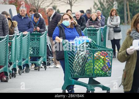 Effetti pandemici del coronavirus: Lunga coda per entrare nel supermercato per lo shopping della drogheria. Milano, Italia - Marzo 2020 Foto Stock