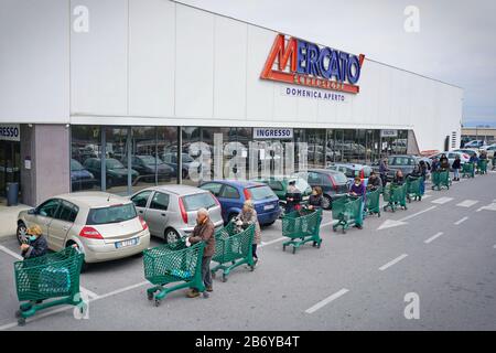 Effetti pandemici del coronavirus: Lunga coda per entrare nel supermercato per lo shopping della drogheria. Milano, Italia - Marzo 2020 Foto Stock