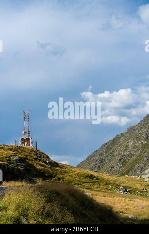 Torre delle cellule in un paesaggio di montagna con nuvole puffy sopra Foto Stock