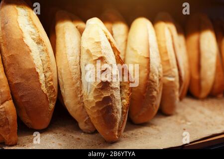 Il pane fresco, fragrante e fresco, della panetteria si trova e viene conservato al banco per la vendita. Foto Stock