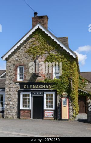 Facciata esterna di un ristorante di campagna in Irlanda del Nord con vecchio negozio di legno fronte e vecchia pompa a benzina Shell fuori Clenaghan's Restaurant. Foto Stock