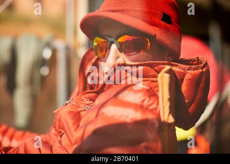 Un ritratto esterno di un uomo in rosso. Foto Stock