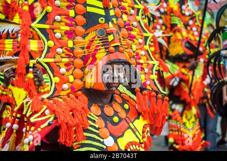 Kalibo, Aklan, Western Visayas nelle Filippine. Un partecipante in ati-atihan festival indossando brighly-colorato fatto a mano costume composto da materiali riciclati e Foto Stock