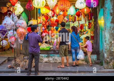 Persone che guardano lanterne di seta per la vendita sulla strada a Hoi An, Quang Nam Provincia, Vietnam Foto Stock