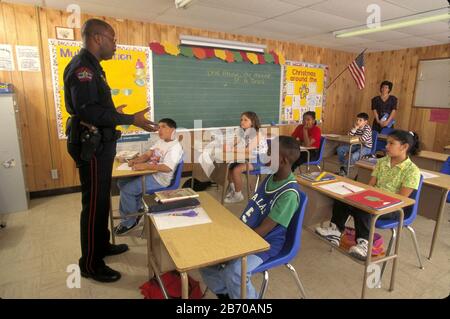 Austin Texas USA: L'ufficiale di polizia nero parla ai quarti gradatori circa i pericoli della droga. SIGNOR ©Bob Daemmrich Foto Stock