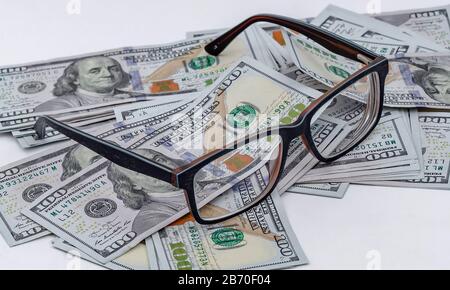 I vetri si trovano sullo sfondo dei dollari americani sparsi Foto Stock