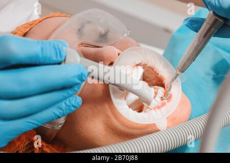 Il paziente visita il dentista per una procedura di ecografia dentale in una clinica dentale.2020 Foto Stock