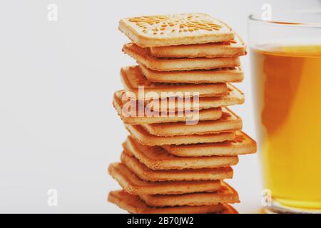 Biscotti di grano e una tazza di tè verde all'interno su sfondo chiaro, contrasto morbido. I biscotti sono disposti nella sala colazioni Foto Stock